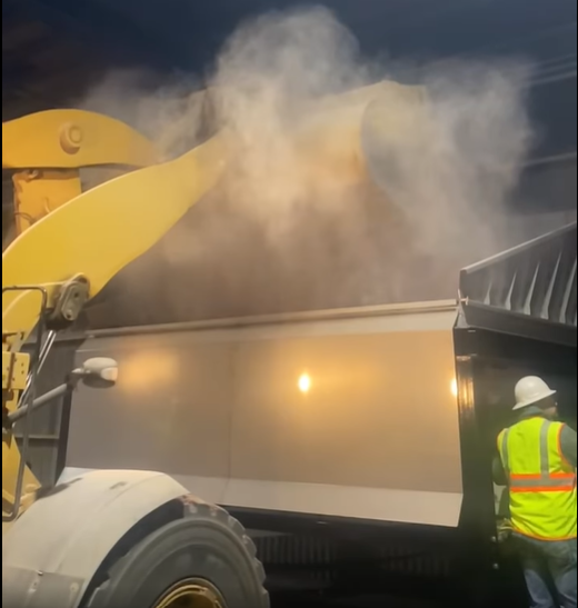 Fertilizer Dust inside a dry fertilizer building with worker and front end loader