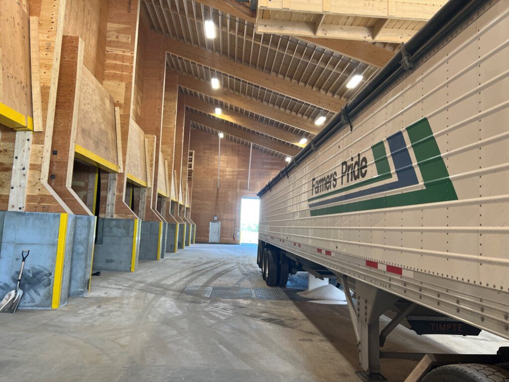 hopper bottom truck basked into a fertilizer plant with concrete floor