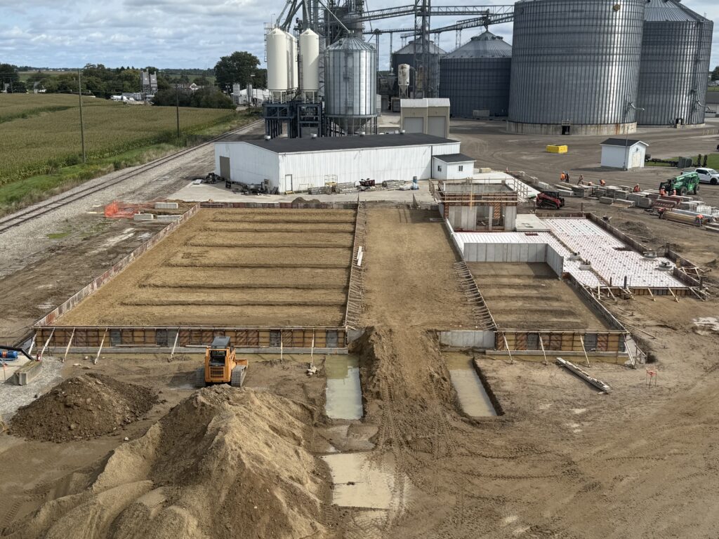 layout of dry fertilizer storage and blend building under construction for a cooperative with grain bins